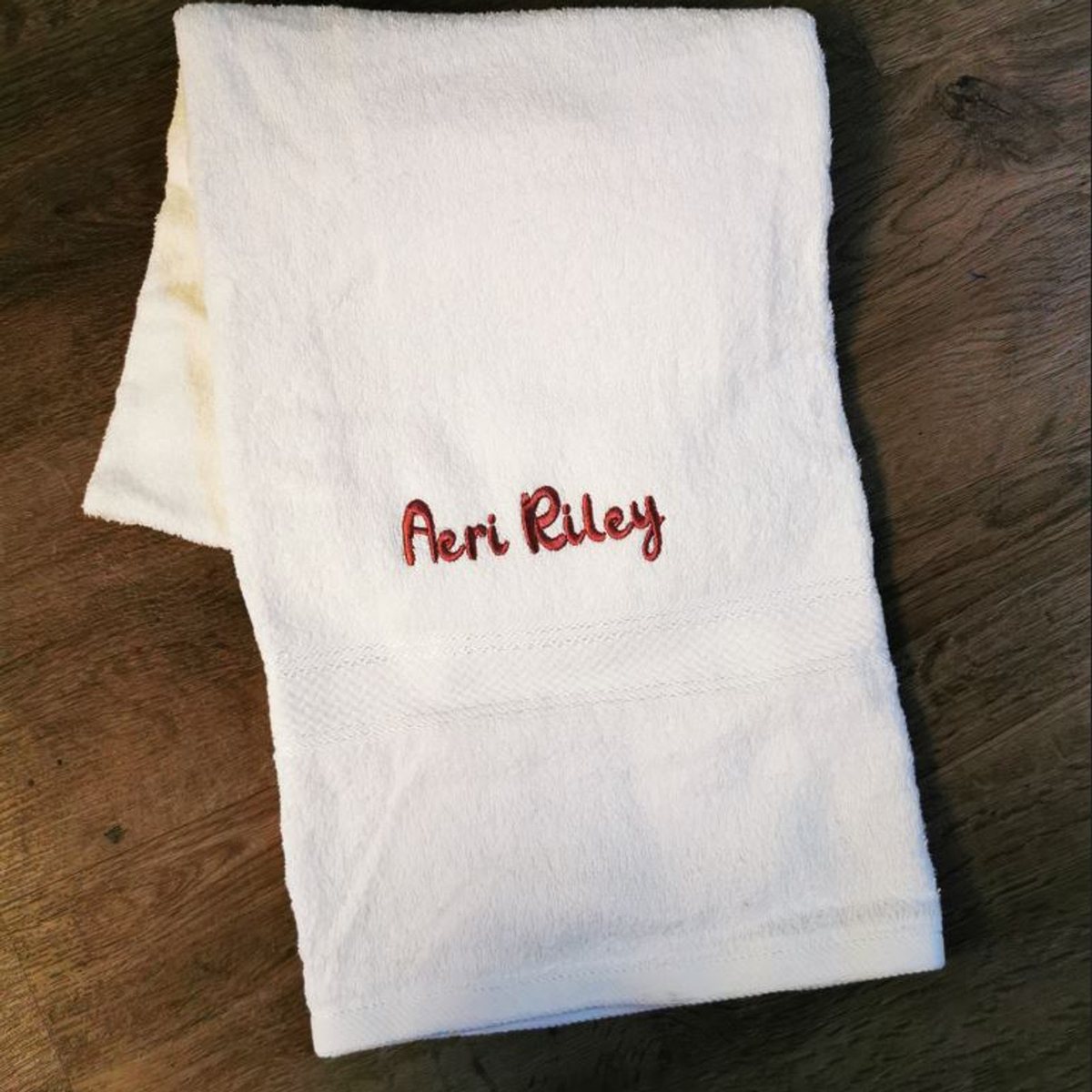 A cotton bath towel embroidered with a name by Baby Butter