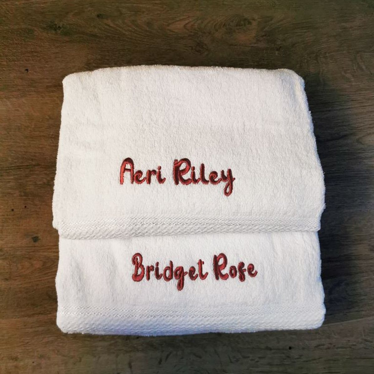 Two cotton bath towels embroidered with names